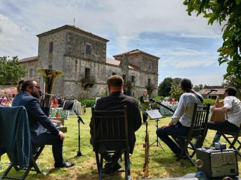 St James Dixie Band - aparece a banda sentada tocando diante dun castelo